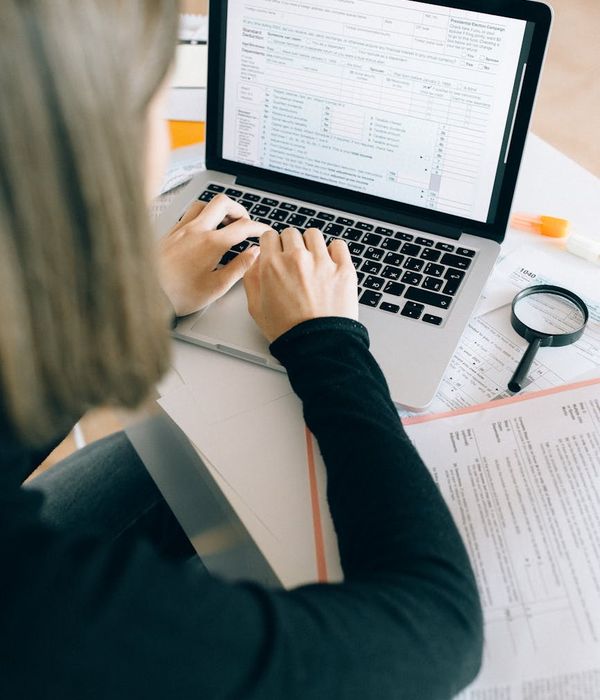 Business analyst reviewing supply chain data on multiple screens